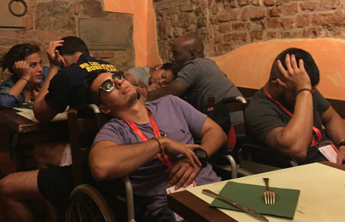 Juan Agudelo naps during dinner after spending a day touring Florence's cobblestone streets by wheelchair.