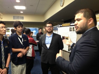 FIU undergrads Jesus Perello, far right, and Anthony Llodra, second from right, explain the value of research to interested students from MAST@FIU.