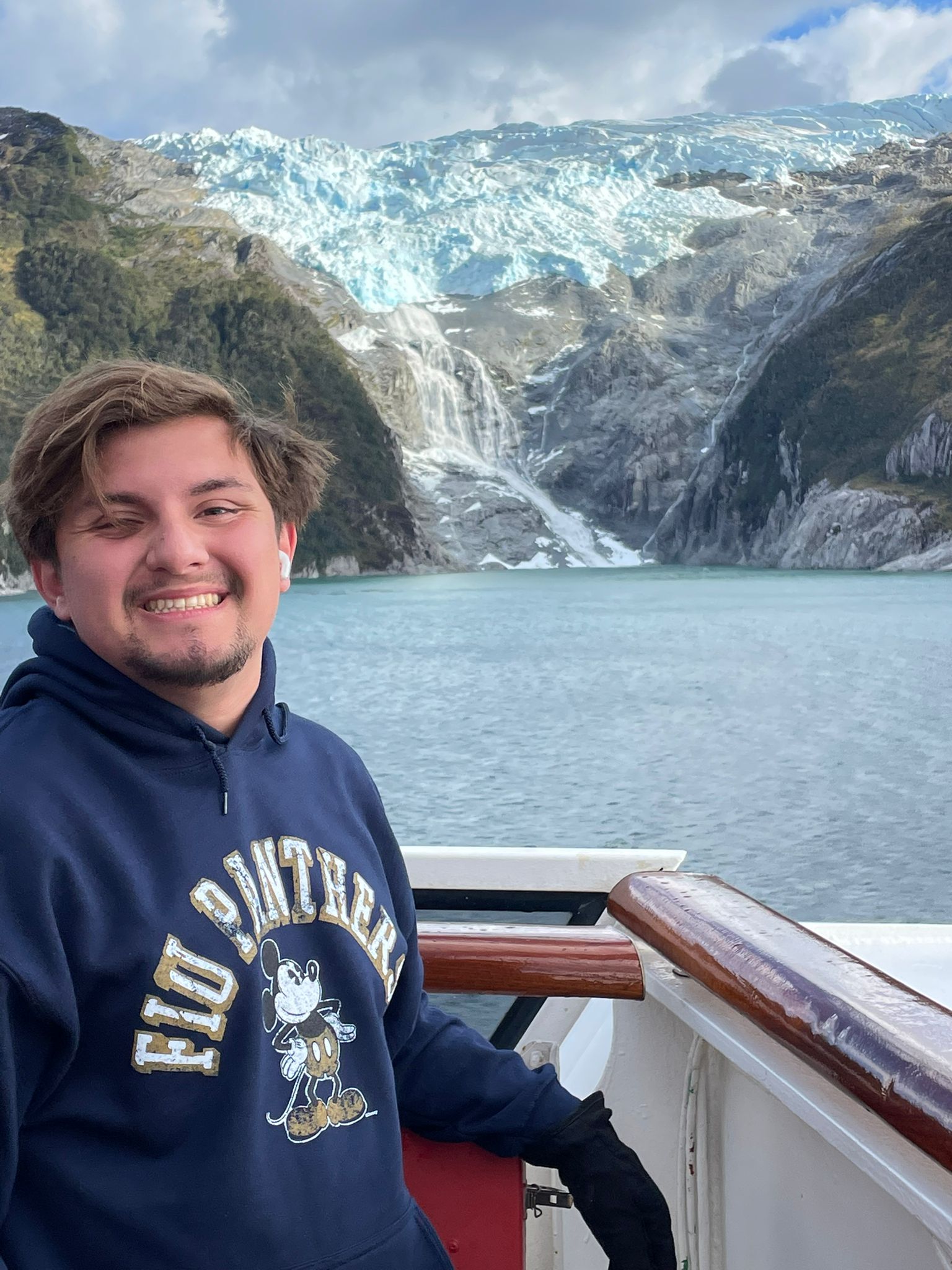 Sebastian Granthon at the bow of the ship with a glacial waterfall