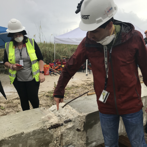 NIST team members observe the exposed reinforcement from a three-story concrete column that search-and-rescue teams extracted from the collapse site for the NIST investigation.