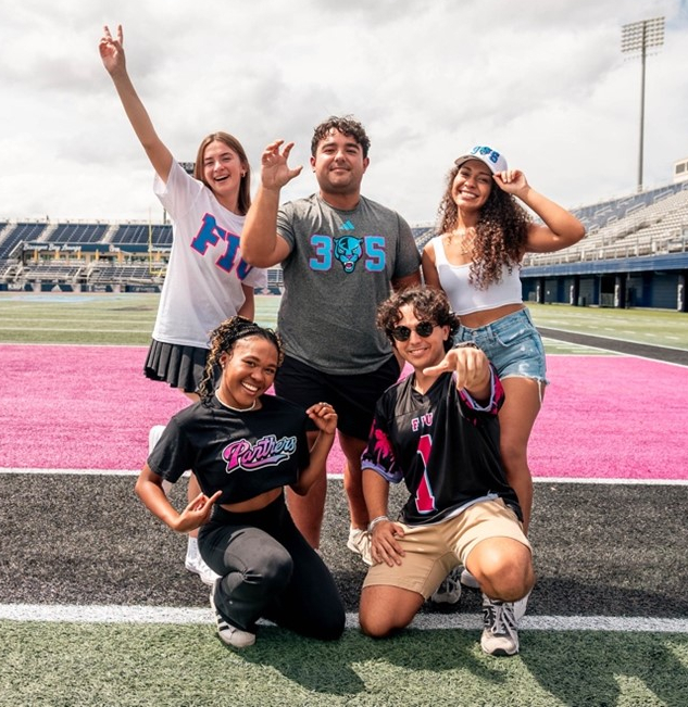 A group of students wear Vice-themed FIU shirts poses at FIU Stadium