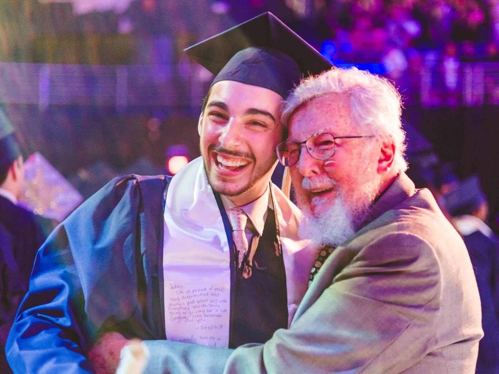 Graduate hugging older relative