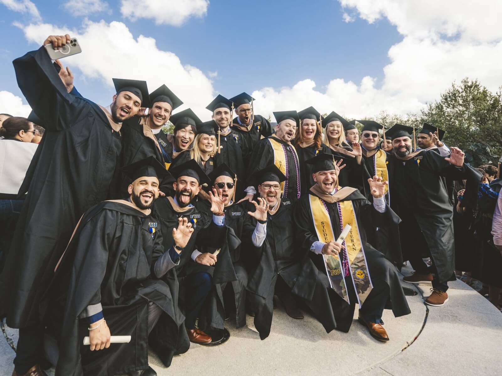 Big group of graduates doing Paws up and cheering