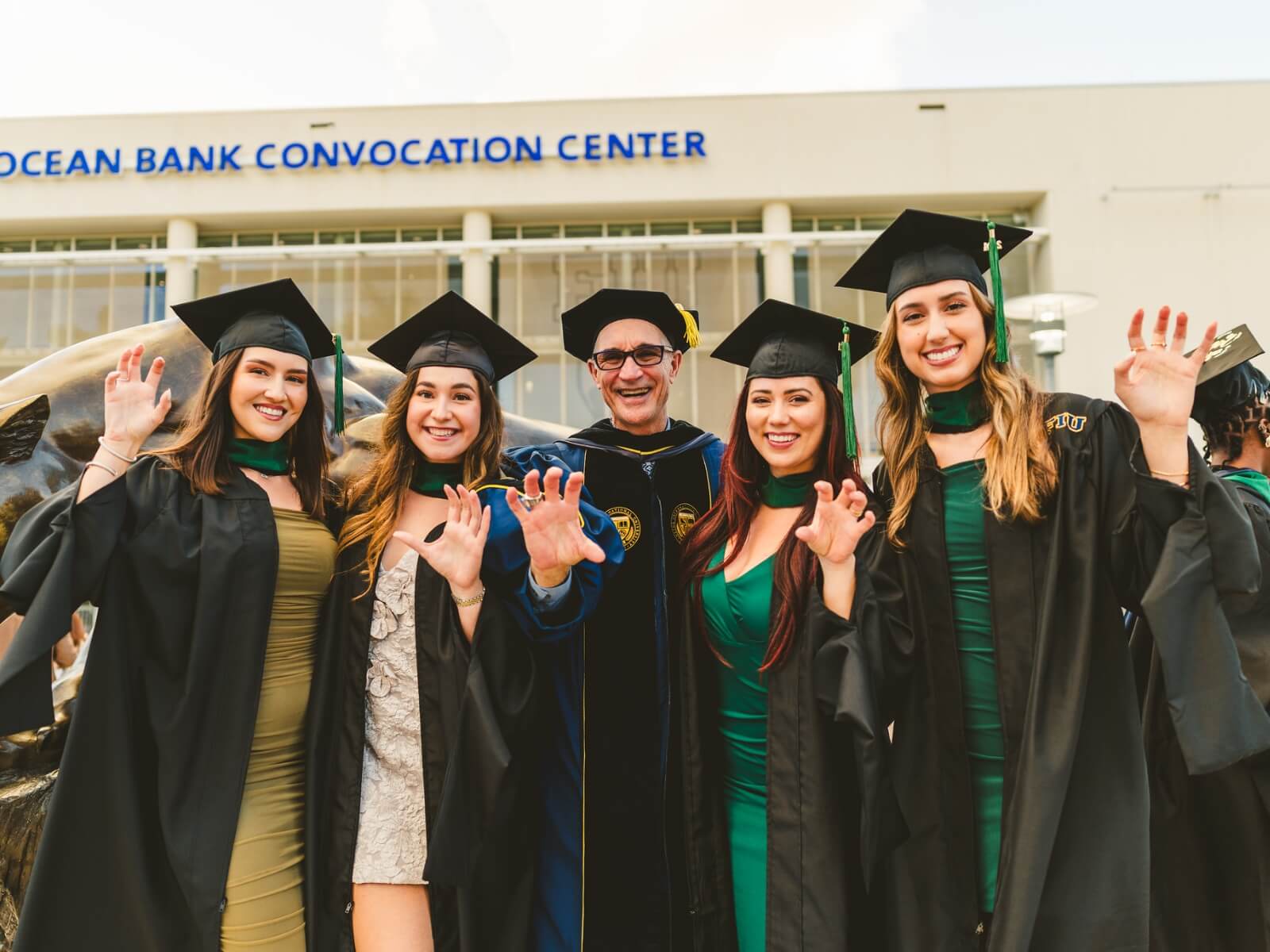 Graduates outside doing Paws Up with Kenneth Jessell