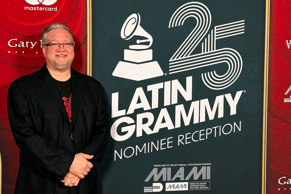 Jamie Ousley in front of Latin Grammy Nominee Reception banner.