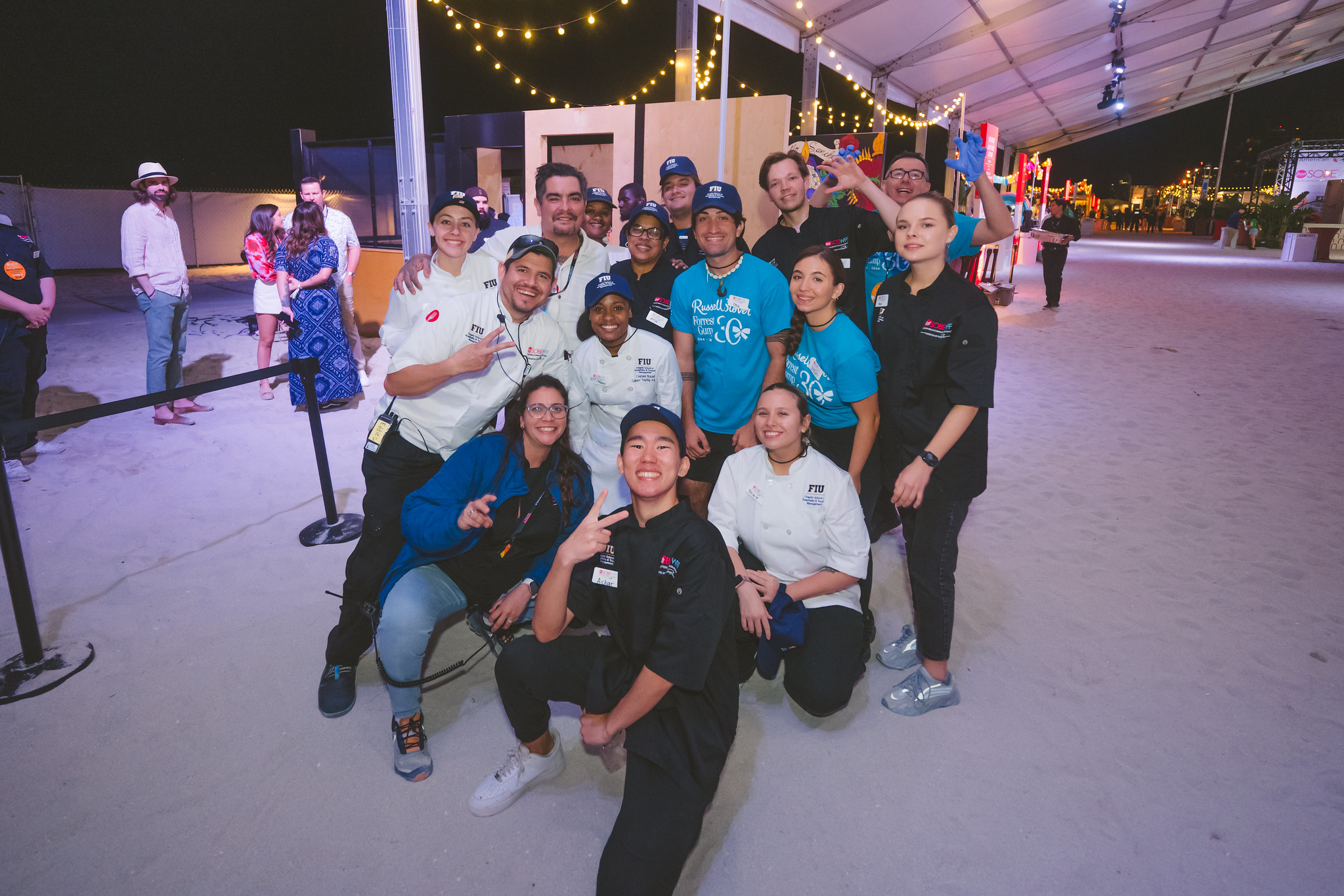 Chef Patricia Falcon (bottom left) pictured with Food Network personality Aaron Sanchez and FIU students.