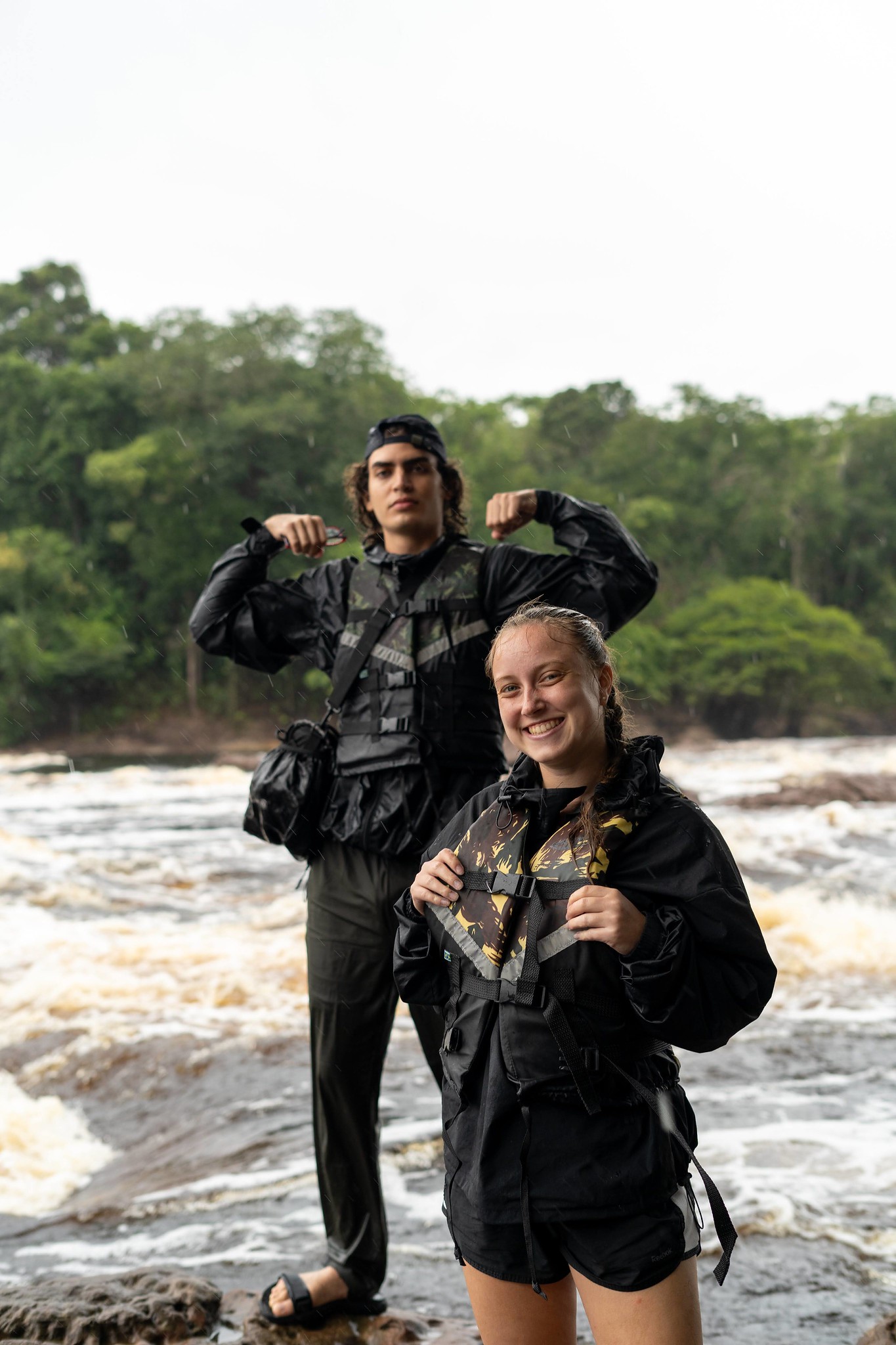 Fabio Lorenzo and Samantha Wagner stand near rapid waters 