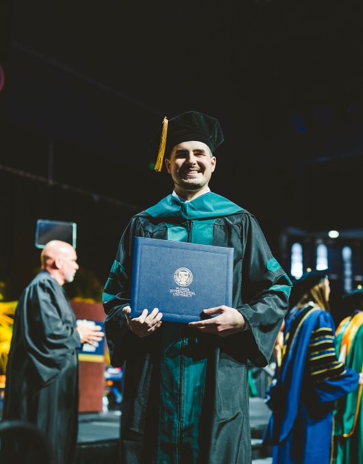 Graduate with diploma in its cover