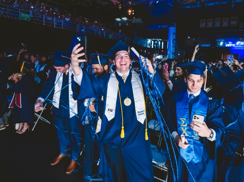 Graduate standing as confetti falls