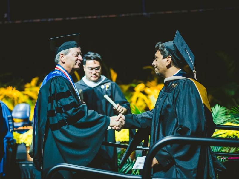 Graduate shaking hands with College of Business Dean William Hardin