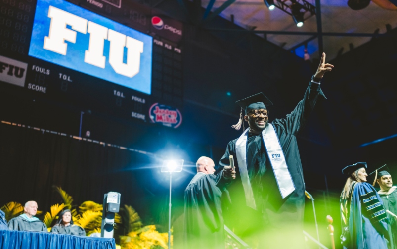 Graduate waving with new diploma