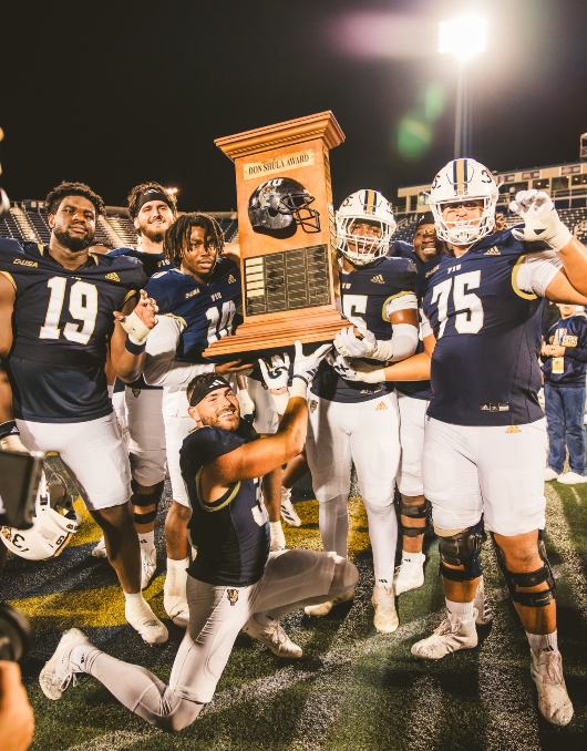 FIU football players celebrate with the Shula Bowl award