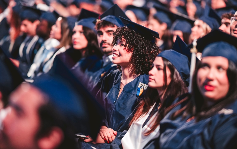 Graduates sitting together and smiling with their diplomas