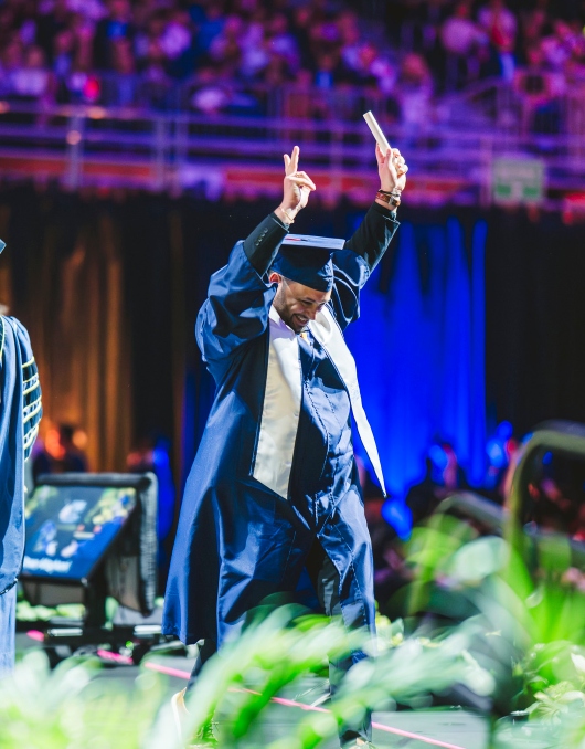 Graduate celebrating with his diploma
