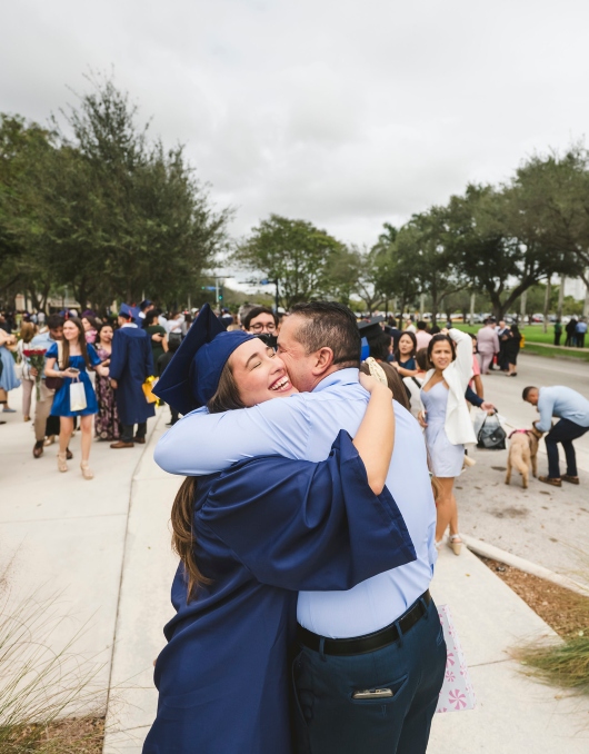 Graduate hugging family member