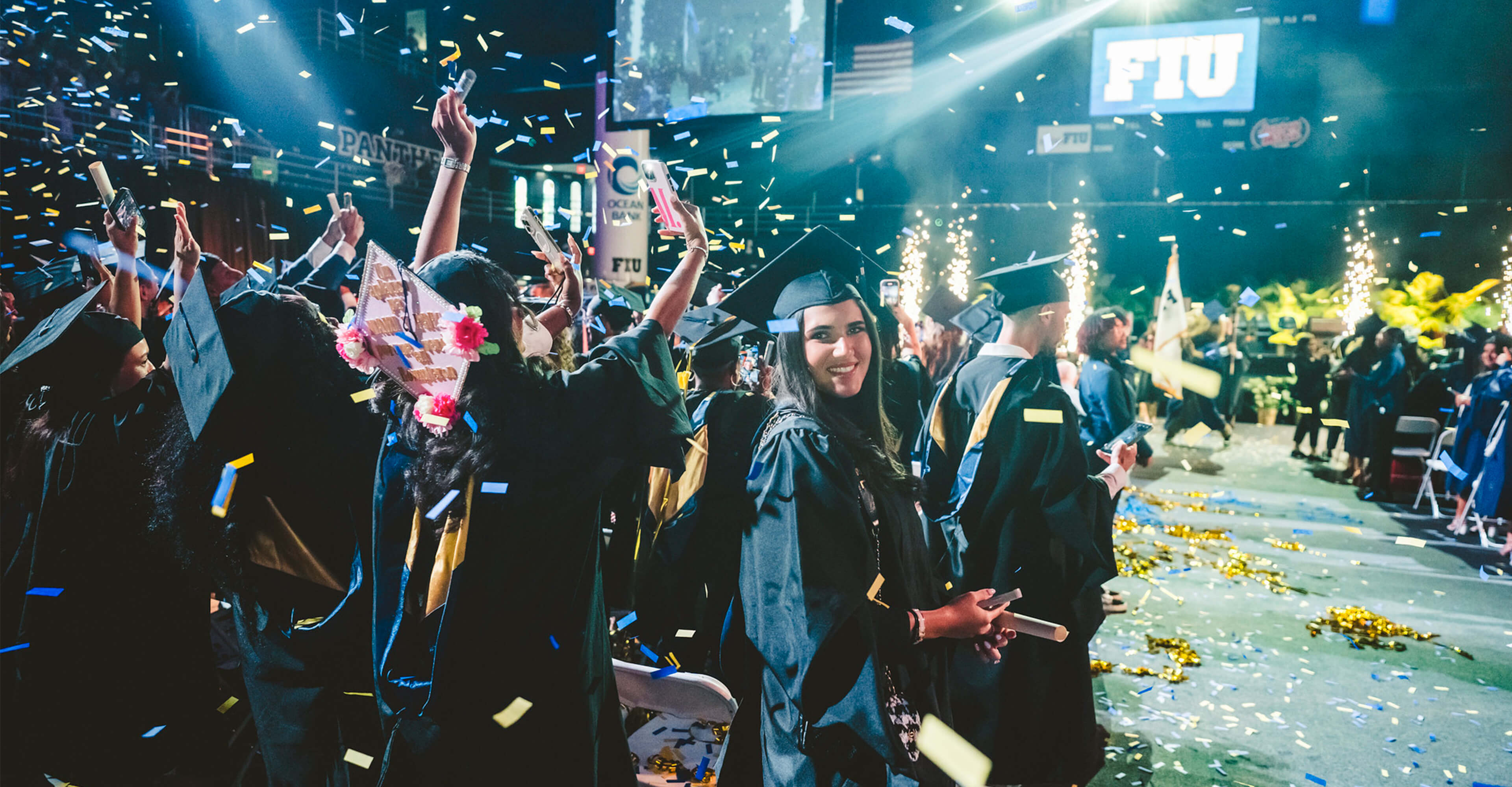 Graduate smiling as confetti drops down