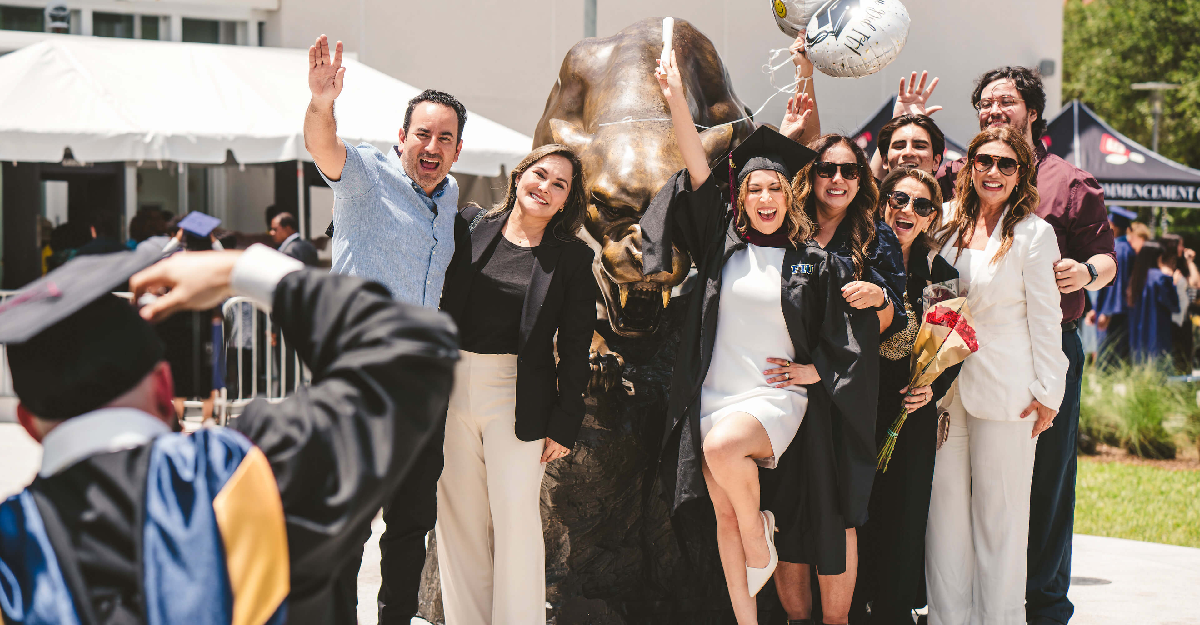 Graduate and her family celebrating on the Panther statue