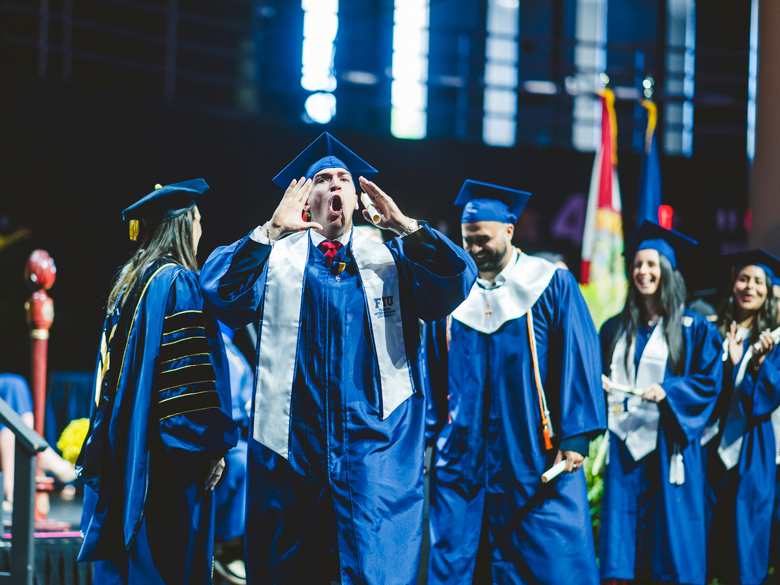 Graduate cheering as he walks off stage
