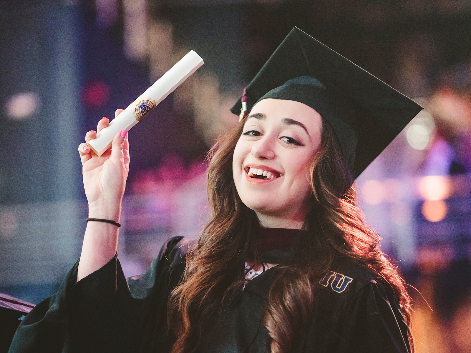 Graduate holding diploma up