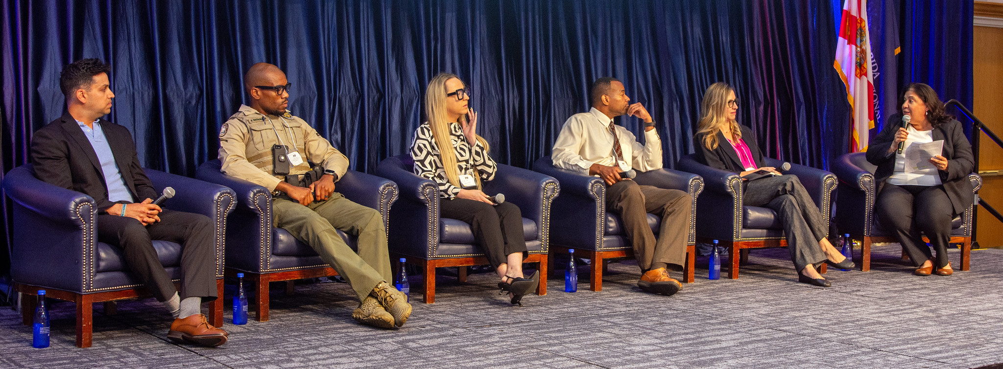 Five panelists sit on a tage discussing careers in public service.