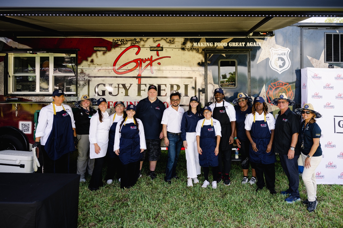 FIU President Jeanette Nuñez (center, right), Chaplin School Dean Michael Cheng (center), Guy Fieri Foundation CEO Brian Daly (center, left) posed for a photo with FIU students and administrators as well as Guy Fieri Foundation staff members.