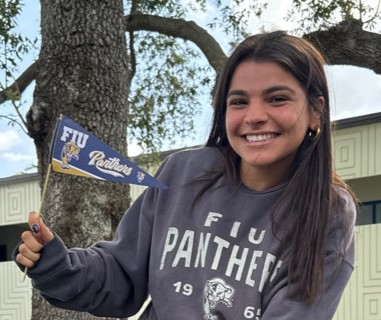 Gabriela Trueba holds up small FIU flag