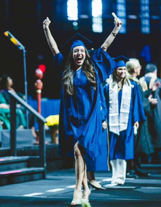 Graduate celebrating with diploma in hand