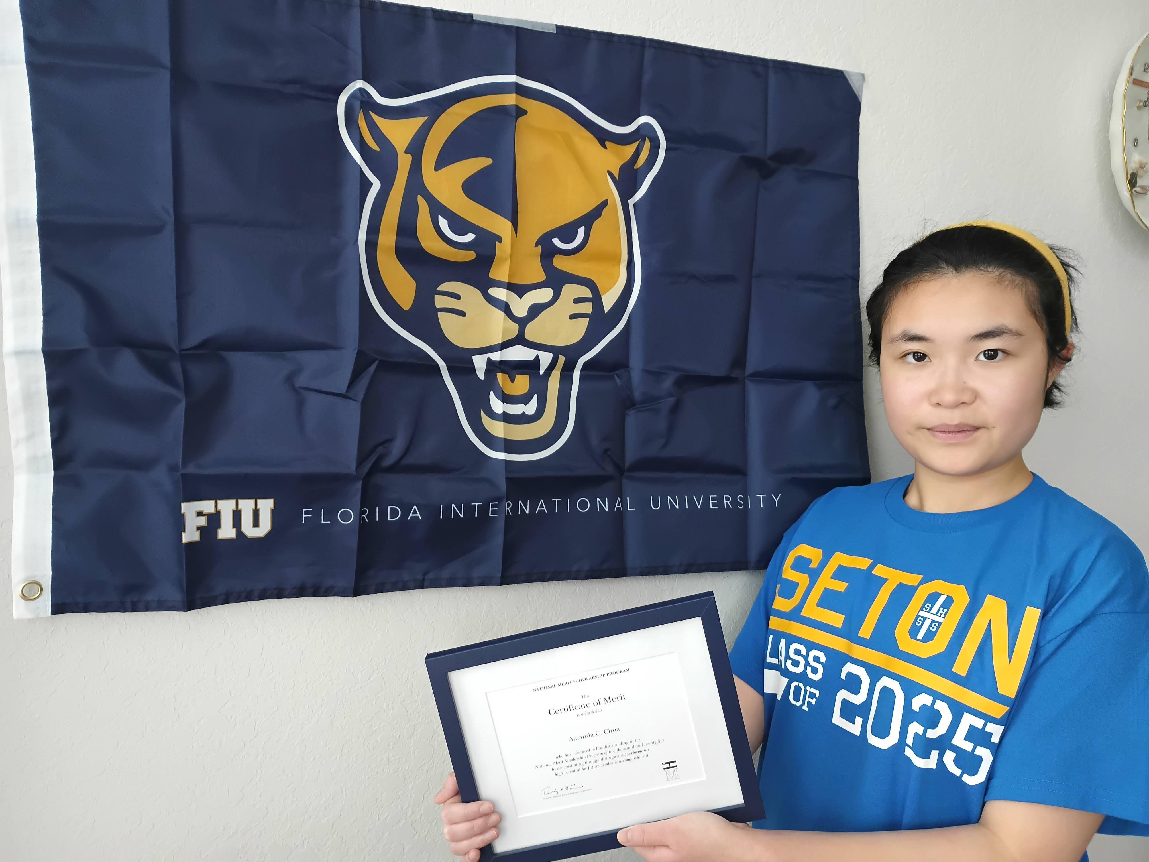 Amanda Chua holding up her National Merit award