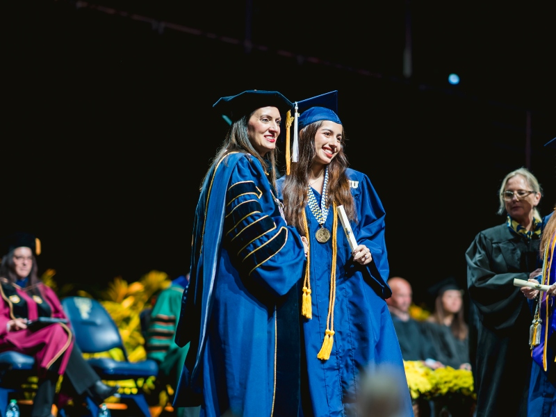 Graduate shaking President Nuñez's hand on stage