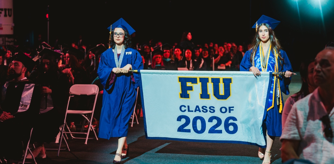 Two students entering with Class of 2026 banner