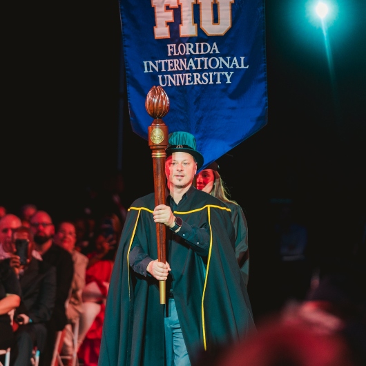 Faculty Noel Barengo entering with banner