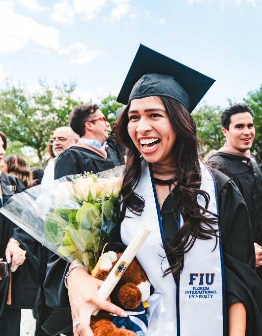 Graduate celebrating with flowers