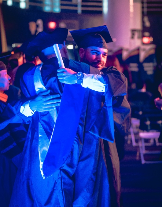 Student being congratulated by a faculty member