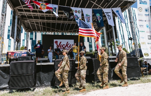 The color guard display the flags while a vocalist sings the National Anthem